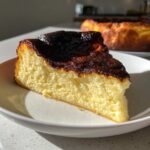 A perfect slice of creamy Basque cheesecake showing its signature dark, caramelized top.