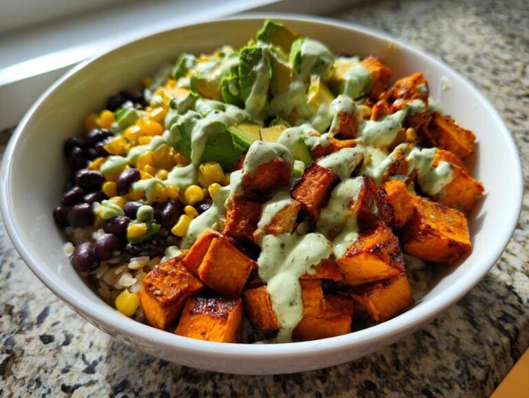 A vibrant sweet potato taco bowl recipe featuring roasted sweet potatoes, black beans, corn, avocado, and a creamy green dressing.